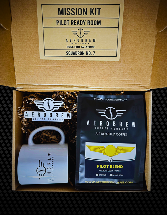 Aero Brew coffee kit with coffee bag, grinder, and branded box on a textured surface.