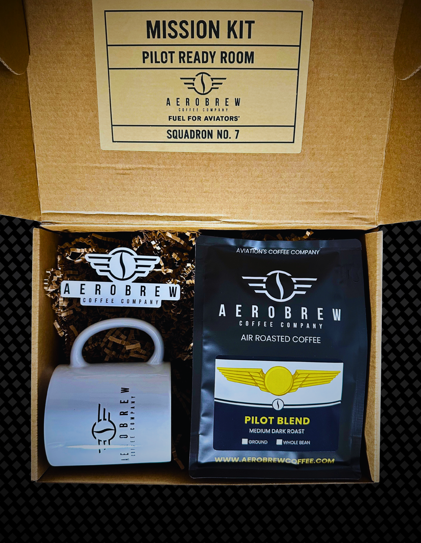 Aero Brew coffee kit with coffee bag, grinder, and branded box on a textured surface.